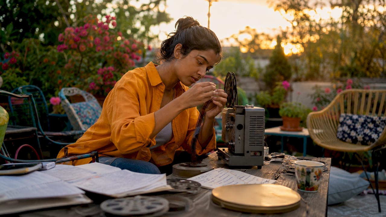 Filmmaker operating film projector in screening booth